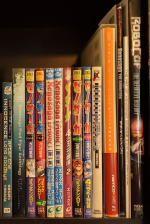 A series of books on a shelf with titles in English and Japanese, mostly pertaining to Xenosaga (several comic anthologies, the Official Design Materials for XSI, and art books for the anime series and XSIII). There is also a copy of the Ghost In The Shell novel After The Long Goodbye and an artbook for the Robocop movies.