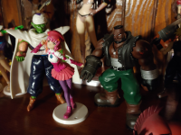 A figure of MOMO on a shelf with other figurines, including Piccolo from Dragon Ball Z and Barret from Final Fantasy VII.
